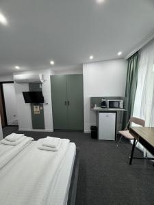 ein Zimmer mit zwei Betten, einem Tisch und einer Küche in der Unterkunft Casa Noa in Marginea