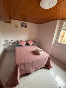 a bedroom with a bed with a pink blanket at Casa Gallopin in Foz