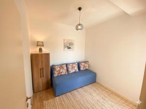 a living room with a blue couch and a lamp at Belvedere in Dobrota +4 photos
