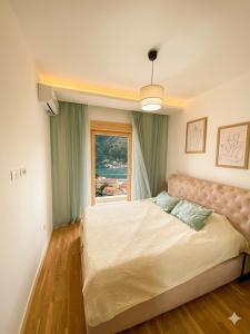 a bedroom with a large bed and a window at Belvedere in Dobrota