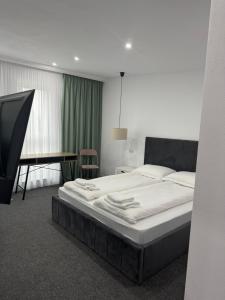 ein Schlafzimmer mit einem großen Bett und einem Schreibtisch in der Unterkunft Casa Noa in Marginea