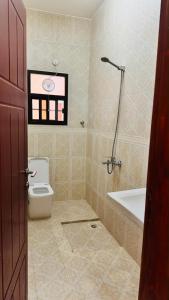 a bathroom with a toilet and a bath tub at فيلا in Salalah