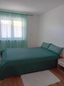 a bedroom with a green bed and a window at Ferienwohnung in Arrach