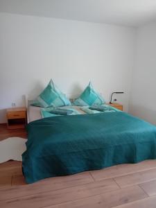 a bed with a blue blanket on top of it at Ferienwohnung in Arrach