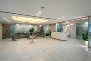 a lobby with couches and a reception desk in a building at Hotel Narenn HITEC CITY in Hyderabad +38 photos