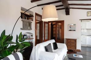 a living room with a white chair and a plant at Vista Menaggio Centro by LoveComo in Menaggio