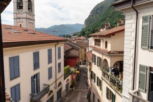 an alley between two buildings with a clock tower at Vista Menaggio Centro by LoveComo in Menaggio