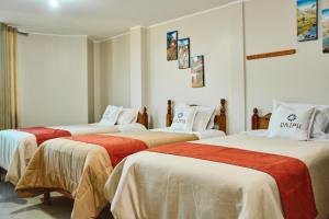 a group of three beds in a room at QAIPU HOTEL in Puquio