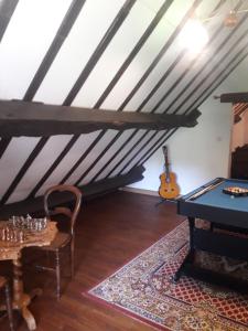 a room with a ping pong table and a guitar at Gîte Le Pont du Soleil in Hyds