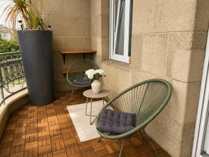 a balcony with two chairs and a vase of flowers at Schängel Chic 2 in Koblenz