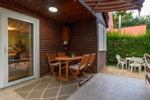 a patio with a wooden table and chairs on a patio at Csendliget Apartman in Dunavarsány +40 photos