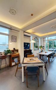 a living room with tables and chairs and windows at 小k咖啡B&B 寵物友善 咖啡廳民宿 in Sanxing