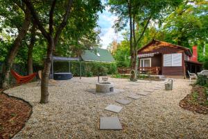 a yard with a tree and a house at Csendliget Apartman in Dunavarsány