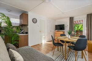 a living room with a table and chairs at Csendliget Apartman in Dunavarsány