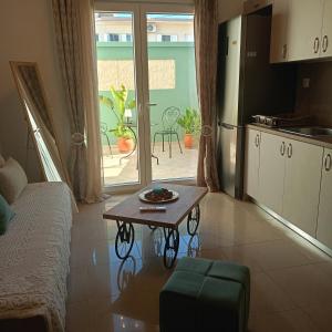 a living room with a table and a kitchen at The Eliana Serenade in Heraklio