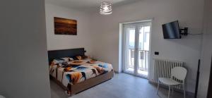 a bedroom with a bed and a chair and a window at A casa di Nonna Peppina a Caggiano in Caggiano