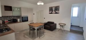 a kitchen and living room with a table and a couch at A casa di Nonna Peppina a Caggiano in Caggiano