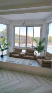 a living room with a large window with two couches at Azure liwa in An Nashshāsh