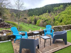 three blue chairs sitting on a deck with a view at Gîte de l'Escoutal La Vallée in Le Bleymard