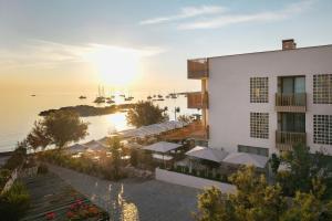 a view of a building and a marina at sunset at Sabatic Formentera Autograph Collection in Es Pujols