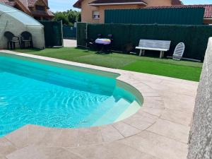 a swimming pool in a yard with a bench and grass at La Casita de Eli in Becerril de la Sierra +8 photos