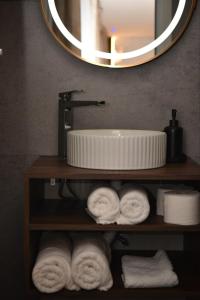 a bathroom with a sink and a mirror and towels at Feli Lodge in Bosanska Gradiška +26 photos