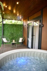 a hot tub on the deck of a house at Feli Lodge in Bosanska Gradiška