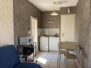a small kitchen with a table and a microwave at Meublé chocolat in Réaumur