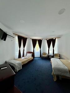 a hotel room with three beds and a television at Vila Randunica in Eforie Sud +22 photos