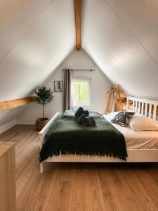 a bedroom with a large bed in a attic at Ecolodges De Dreef Guesthouse in Renesse