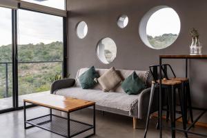 a living room with a couch and two circular windows at Villa Toscana I - Gran Vista y Tranquilidad in Villa Serrana +46 photos