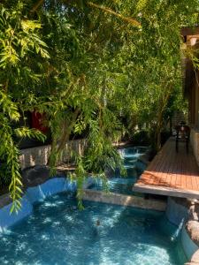 a swimming pool with a wooden walkway and trees at Royal Park Hotel Corlu Bed and Breakfast in Tekirdağ