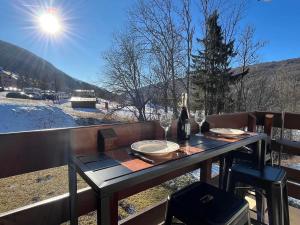 a table with a bottle of wine on a balcony at Le cocon dans les nuages in Lélex