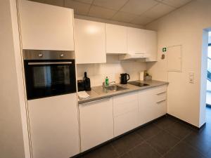 a kitchen with white cabinets and a sink at Schängel Chic 03 in Koblenz