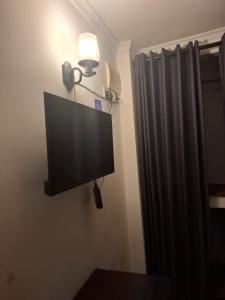 a flat screen tv on the corner of a room at Enderamulla Casual Home in Wattala