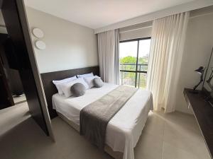 a bedroom with a bed and a large window at Studio Luxuoso com vista surpreendente in Macapá +27 photos