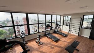 a gym with treadmills and ellipticals in a room with windows at Studio Luxuoso com vista surpreendente in Macapá