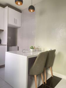 a kitchen with a white counter and two chairs at Green Paradise Hotel in Mogadishu +10 photos