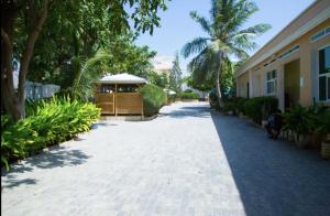 a walkway with a building and a palm tree at Green Paradise Hotel in Mogadishu