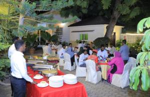 a group of people sitting at tables with plates at Green Paradise Hotel in Mogadishu