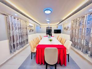 a dining room with a red table and chairs at Green Paradise Hotel in Mogadishu
