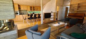 a living room and kitchen with a couch and chairs at Villa Verde by Hvalstrand beach in Nes