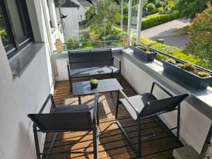 two chairs and a table on a balcony with plants at WOLL Forest in Schmallenberg