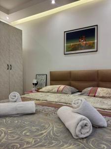 a bedroom with two beds and towels on the floor at APARTMAN BAMBUS in Lug