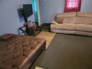 a living room with a brown leather couch and a couch and a couch at ARMANI MANOR rustic spacious 2br unit 1 in Wildwood