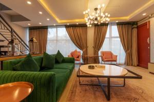 a living room with a green couch and a table at 3 BEDROOMS Premium Private Cottage In Murree Mountains in Murree