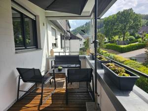 a balcony with chairs and plants on a house at WOLL Forest in Schmallenberg