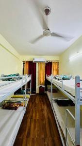 a room with three bunk beds and a ceiling at Awara Hostels and Dormitory in Lucknow