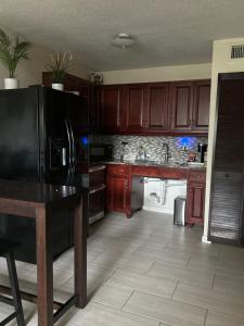 a kitchen with a black refrigerator and wooden cabinets at Clearwater Beach Getaway Clearwater in Clearwater +4 photos
