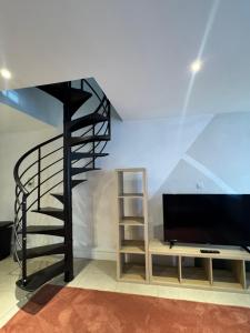 a living room with a spiral staircase and a tv at Yamohome in Brussels